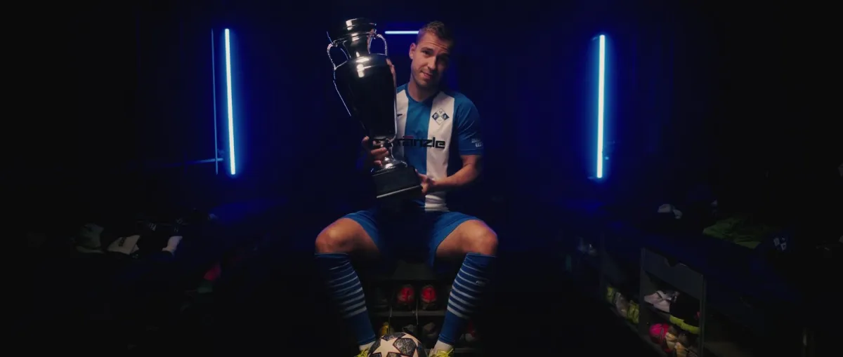 Standbild aus dem Imagefilm für den FV Illertissen: Spieler mit Pokal in der Kabine