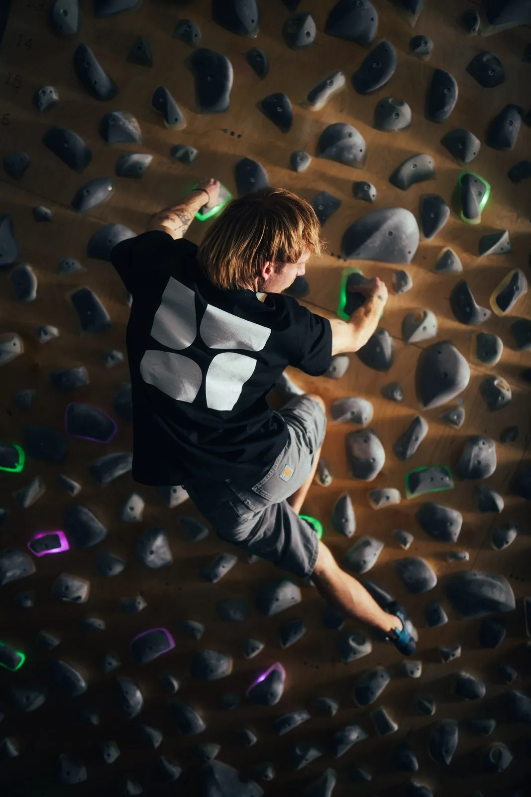 The Boulder Room: Kletterer an der Boulderwand von hinten