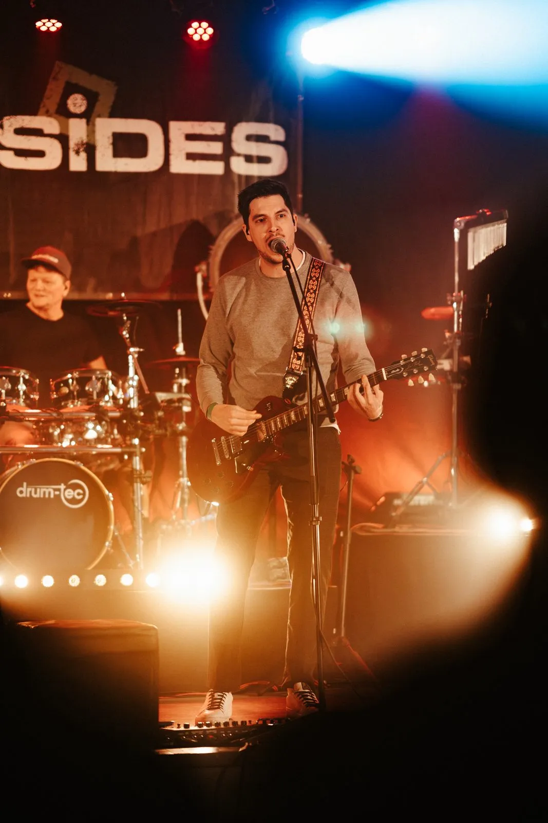 Foursides: Sänger mit Gitarre im warmen Gegenlicht