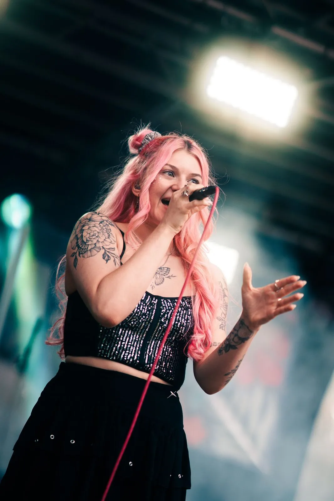 Konzert von TIYH: Sängerin mit pinken Haaren singt im Nebel